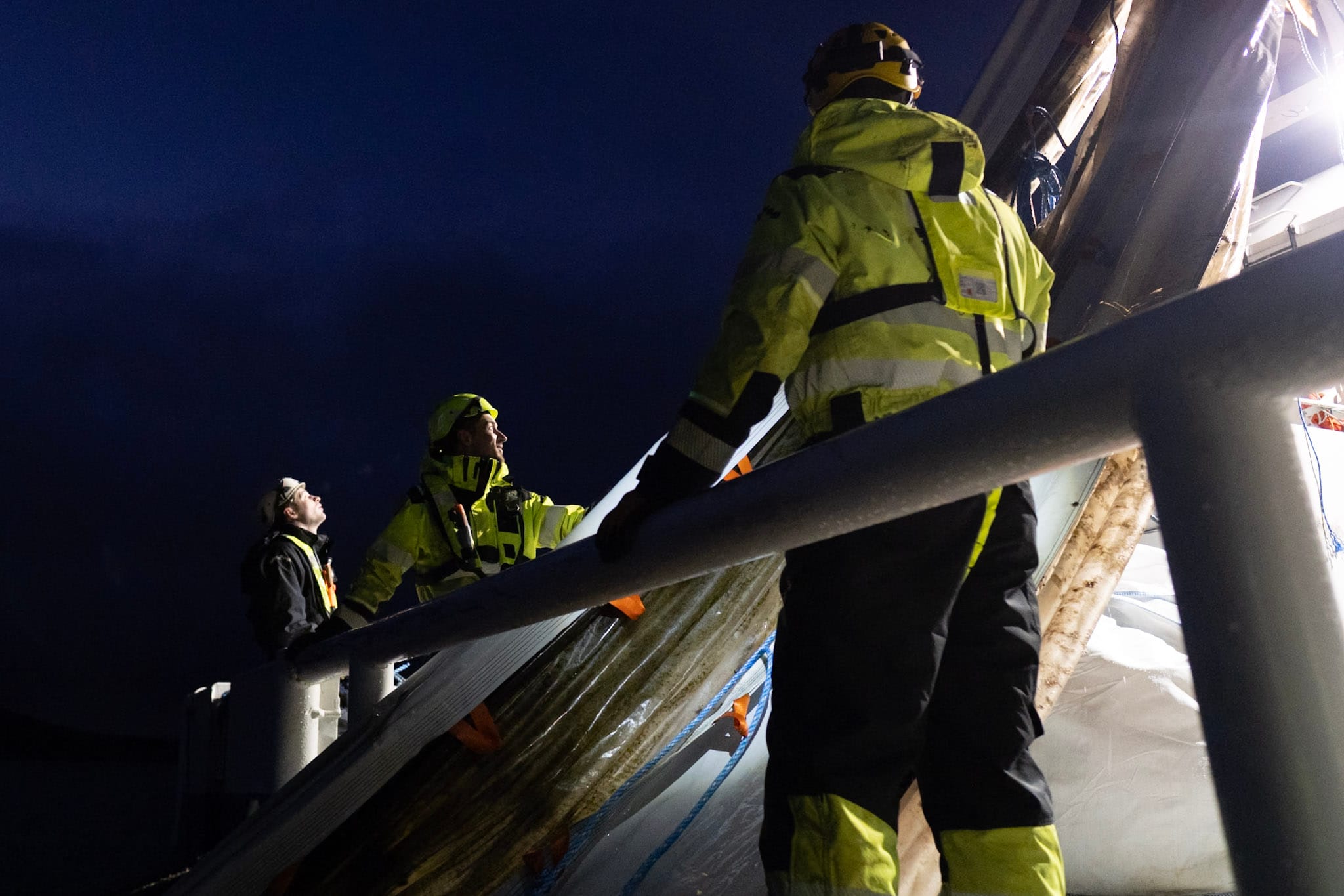Mannskap i arbeid med nøter på MS Akva Fighter under mørketiden