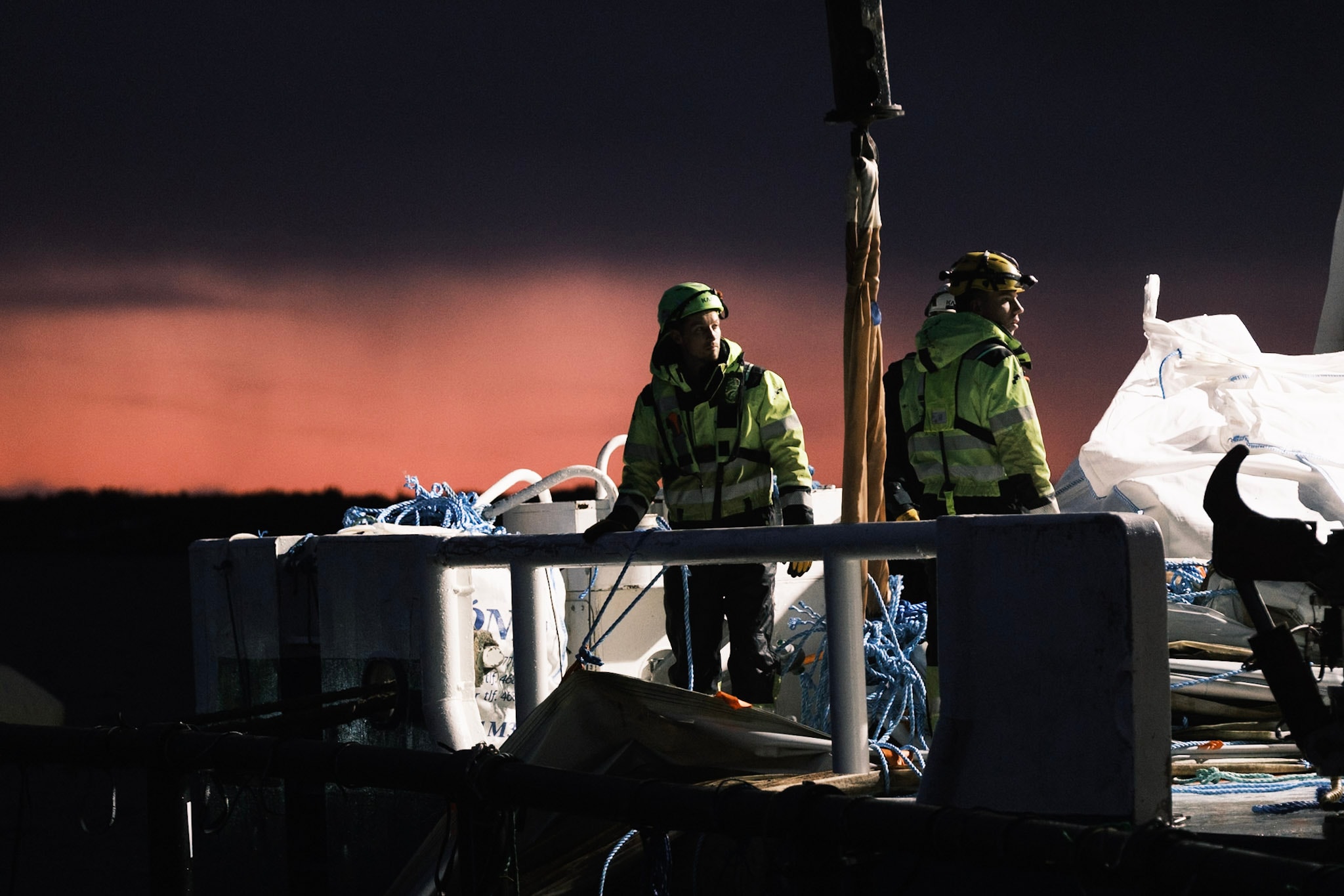 Mannskap på dekk av MS Akva Fighter i solnedgang, Troms